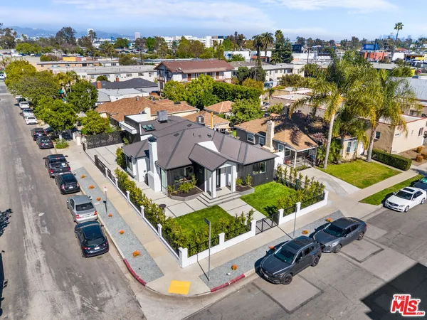 an aerial view of residential houses with outdoor space and parking