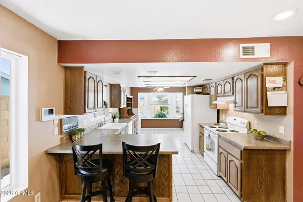 a kitchen with stainless steel appliances kitchen island granite countertop a table chairs in it and wooden floors