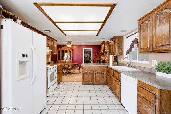 a large white kitchen with a stove a sink dishwasher and a refrigerator