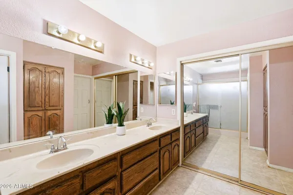 a bathroom with double vanity sinks and a large mirror