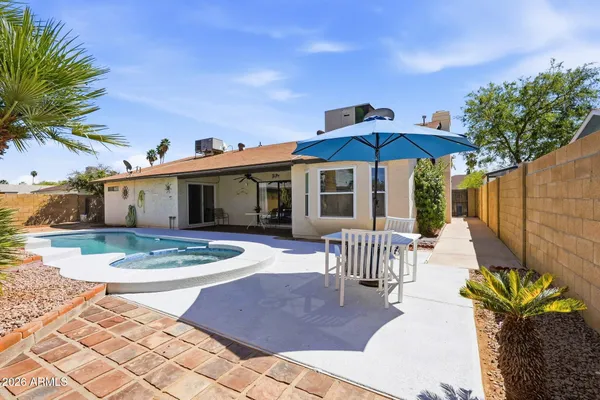 a patio with a table and chairs under an umbrella