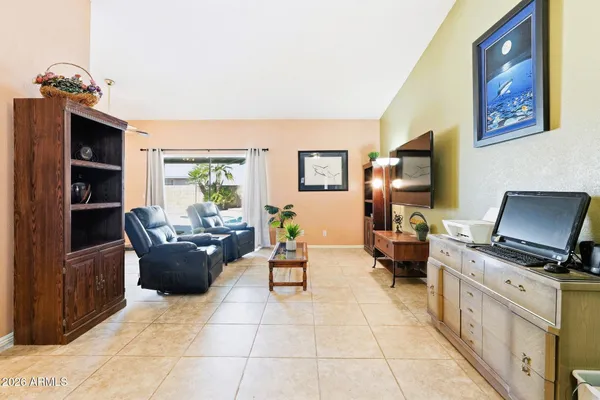 a living room with furniture a chandelier and a flat screen tv