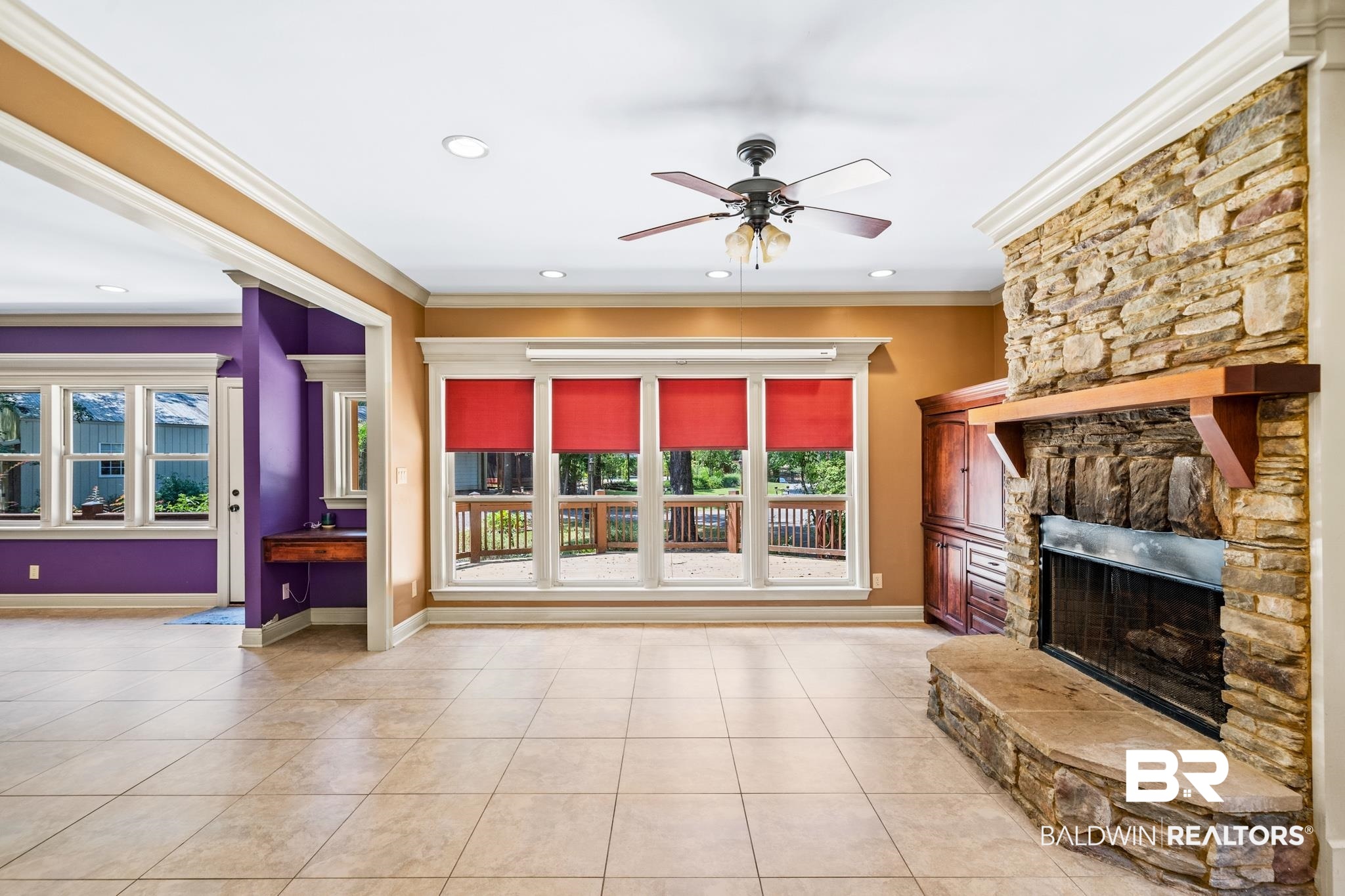 8321 Dixon Road Bay Minette, AL 36507 - Photo 31 of 79 Unfurnished living room featuring ceiling fan, light tile patterned floors, a stone fireplace, and crown molding