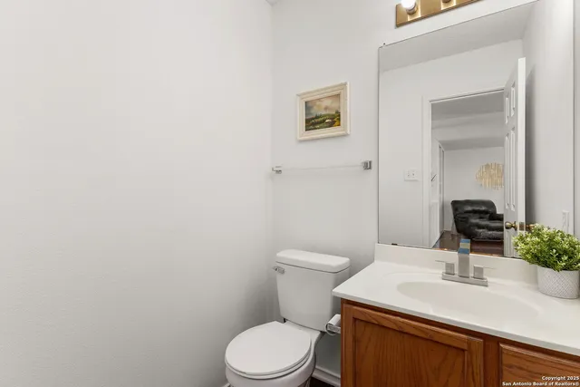 a bathroom with a granite countertop toilet sink and mirror