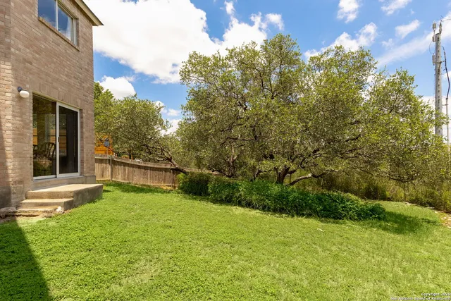 a view of an house with backyard space and balcony