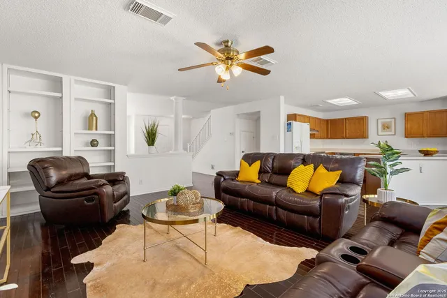 a living room with furniture ceiling fan and a rug