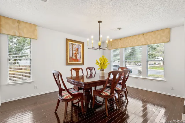 a dining room with furniture a chandelier and wooden floor
