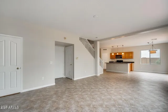 a view of a big room with wooden floor and windows