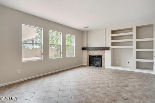 a view of an empty room with a window and fireplace