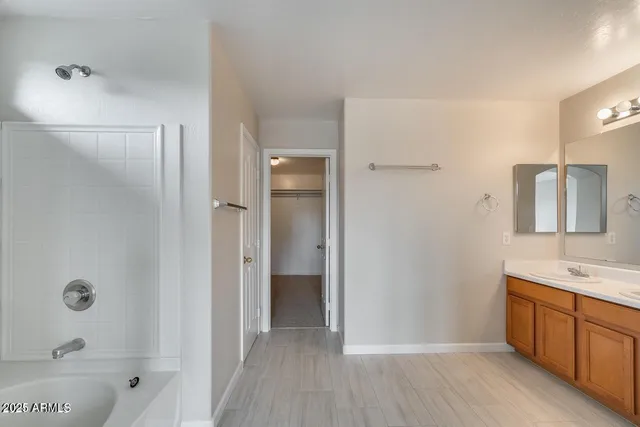 a bathroom with a tub sink and mirror