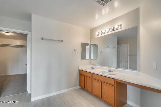 a spacious bathroom with a double vanity sink and a mirror