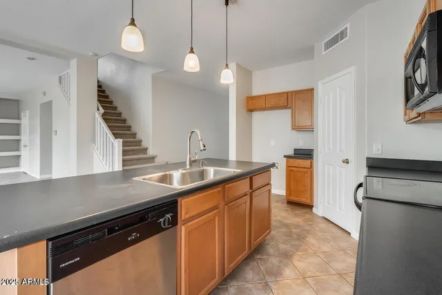a kitchen with stainless steel appliances granite countertop a sink and a stove