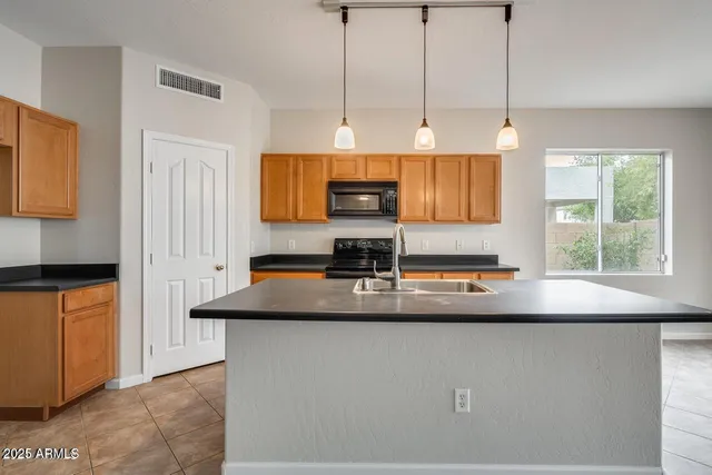 a kitchen with stainless steel appliances granite countertop a sink a stove and a microwave oven