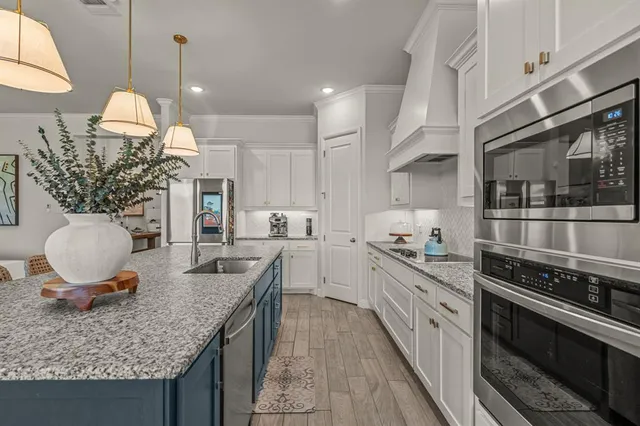 a kitchen with granite countertop a sink stainless steel appliances and cabinets