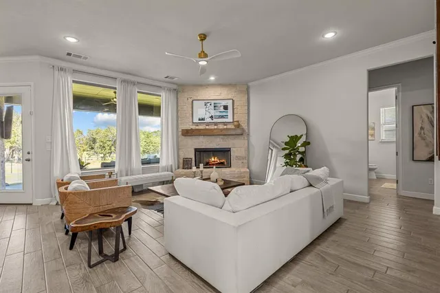 a living room with fireplace furniture and a large window