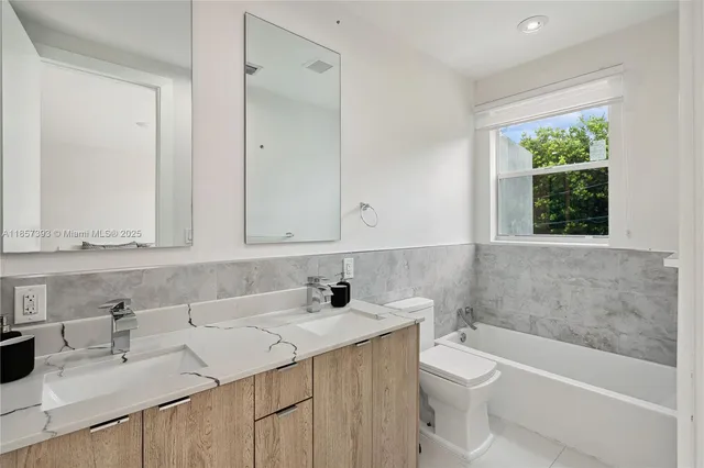 a bathroom with a double vanity sink mirror and shower