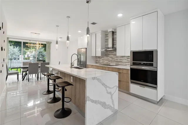 a kitchen with stainless steel appliances a stove a sink and a refrigerator