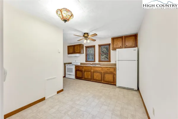 an empty room with windows and cabinet
