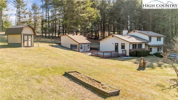 a view of a house with a backyard and a tree