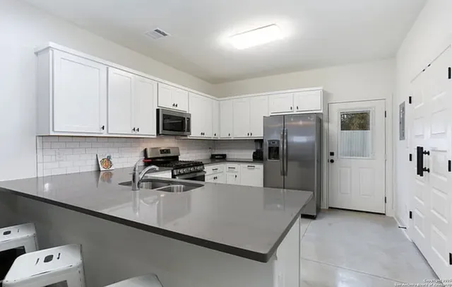 a kitchen with stainless steel appliances a refrigerator sink and microwave