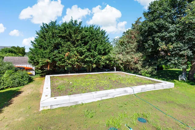 a view of a hallway to a bedroom with bed and wooden floor