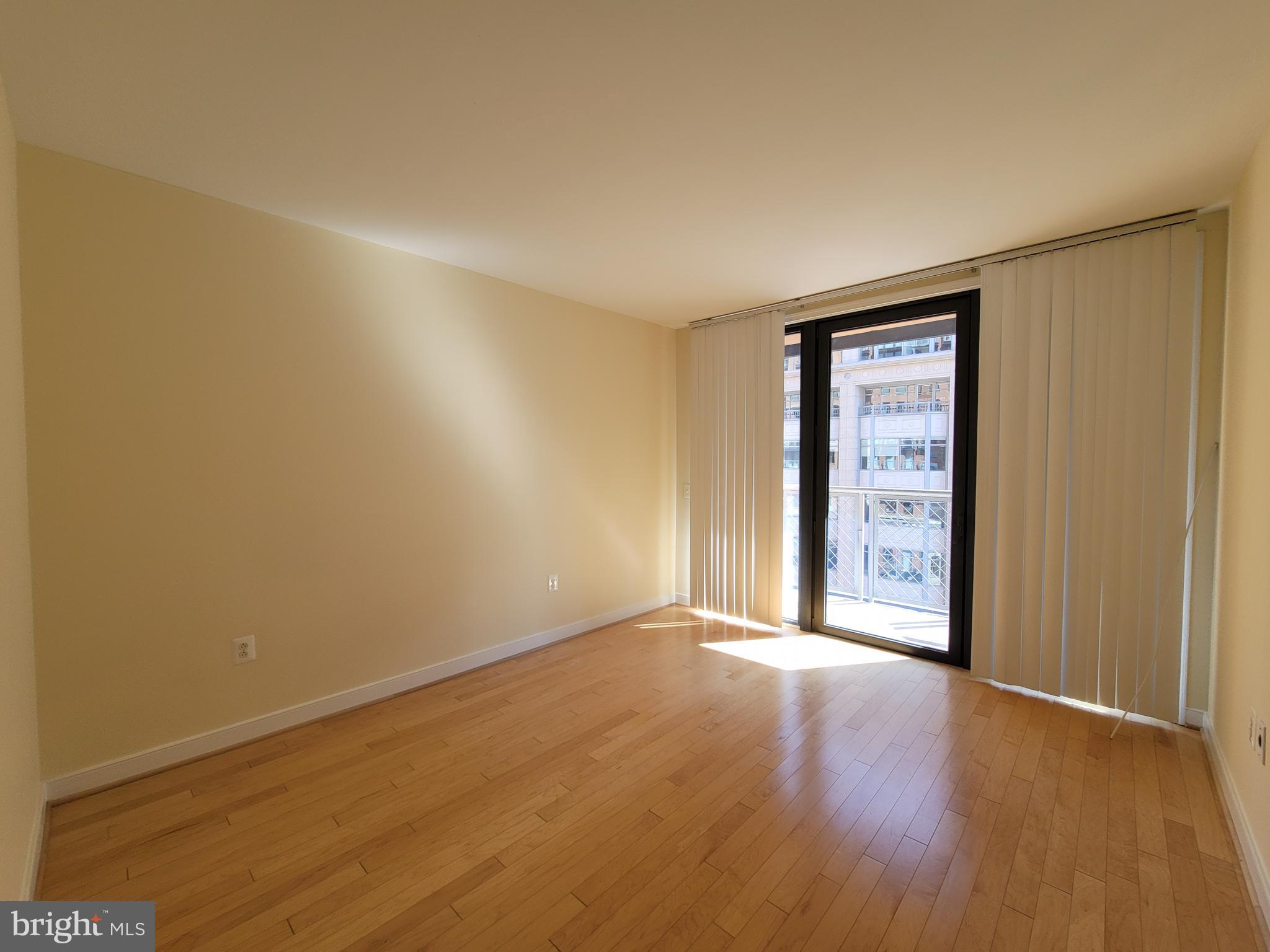 631 D Street Northwest, Unit 733 Washington, DC 20004 - Photo 16 of 87 a view of an empty room with wooden floor and a window