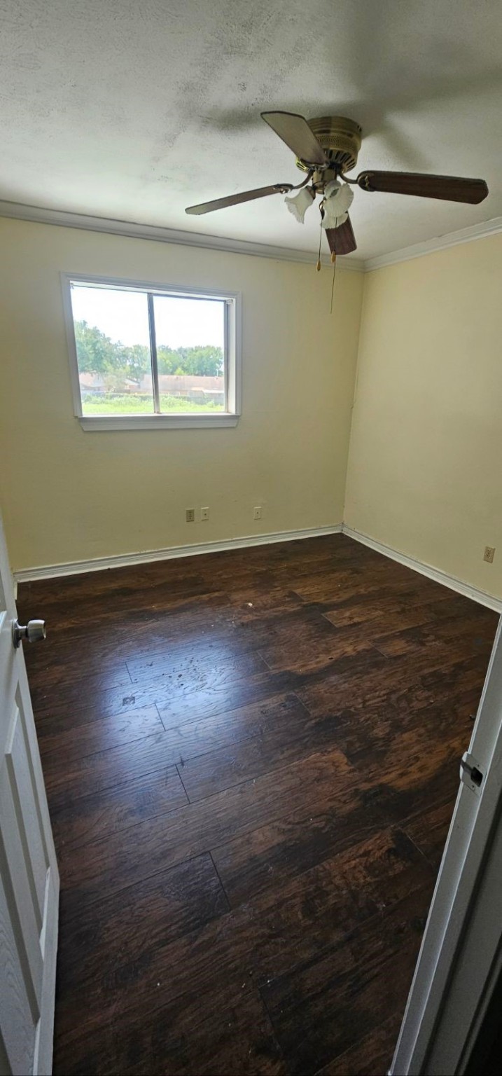 5002 Ripple Creek Drive Baytown, TX 77521 - Photo 2 of 11 en empty room with wooden floor fan and windows