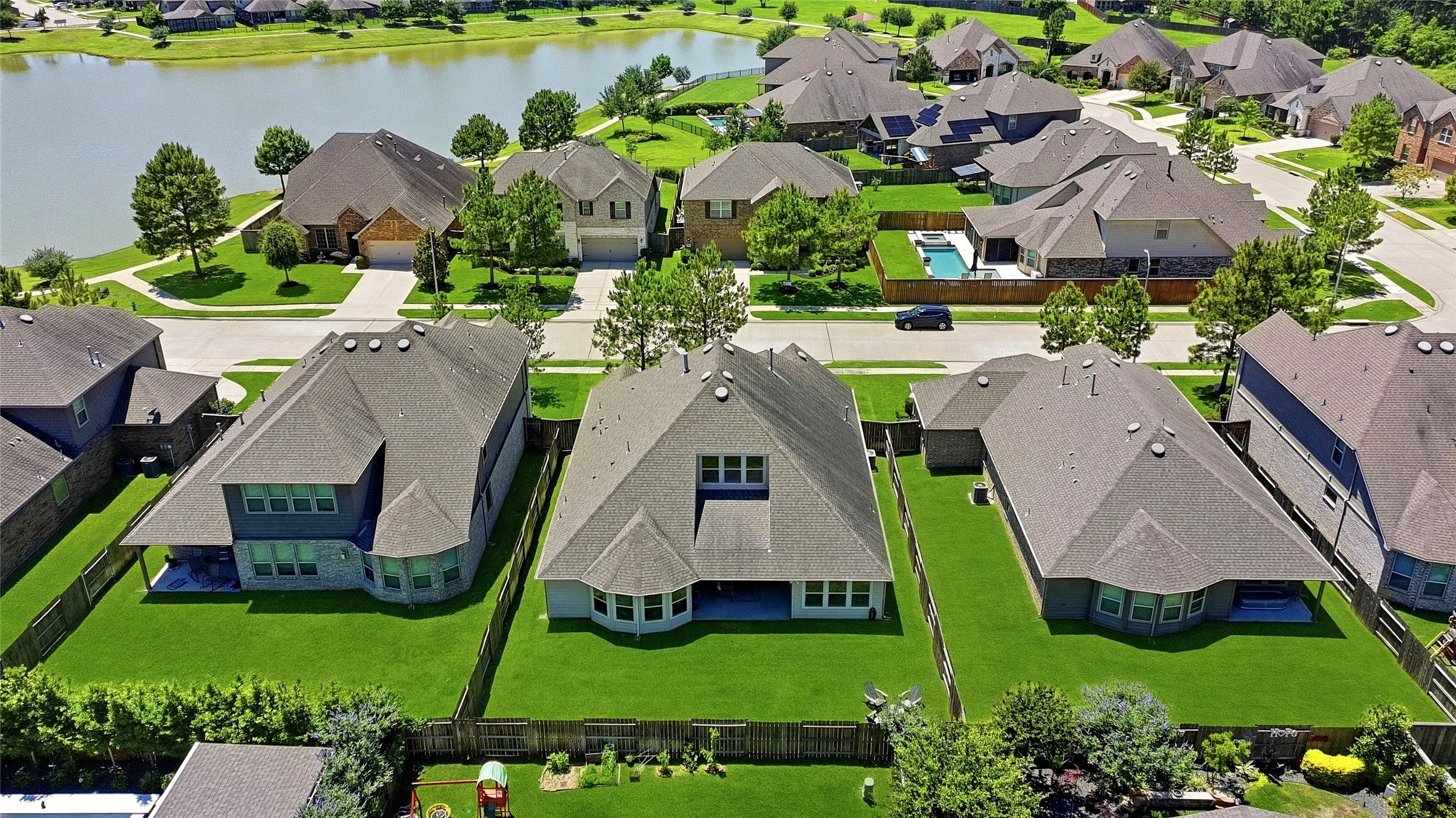 17834 Maple Ash Drive Spring, TX 77379 - Photo 41 of 50 This aerial photo showcases a suburban neighborhood The houses have spacious backyards, and some are near a tranquil lake. The area appears peaceful and family-friendly, with neatly arranged streets and greenery.