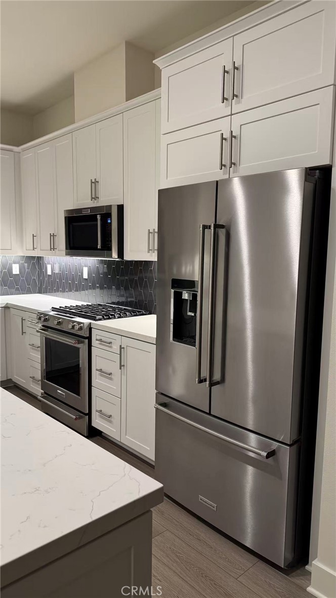16432 Compass Avenue Tustin, CA 92782 - Photo 14 of 35 a kitchen with stainless steel appliances a refrigerator stove and microwave