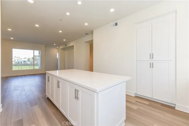 a view of a hallway with wooden floor and chandelier