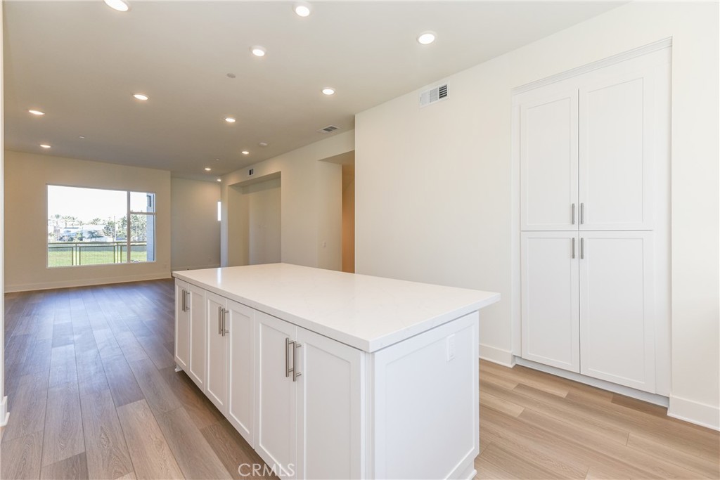 16432 Compass Avenue Tustin, CA 92782 - Photo 17 of 35 a view of a hallway with wooden floor and chandelier