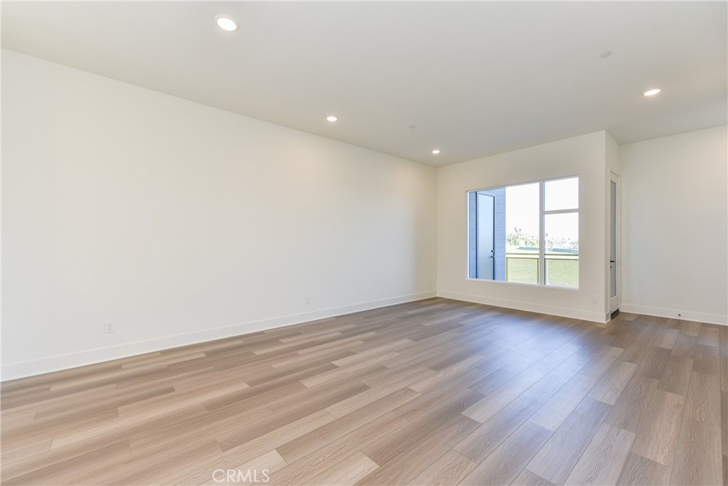 16432 Compass Avenue Tustin, CA 92782 - Photo 10 of 35 an empty room with wooden floor and windows