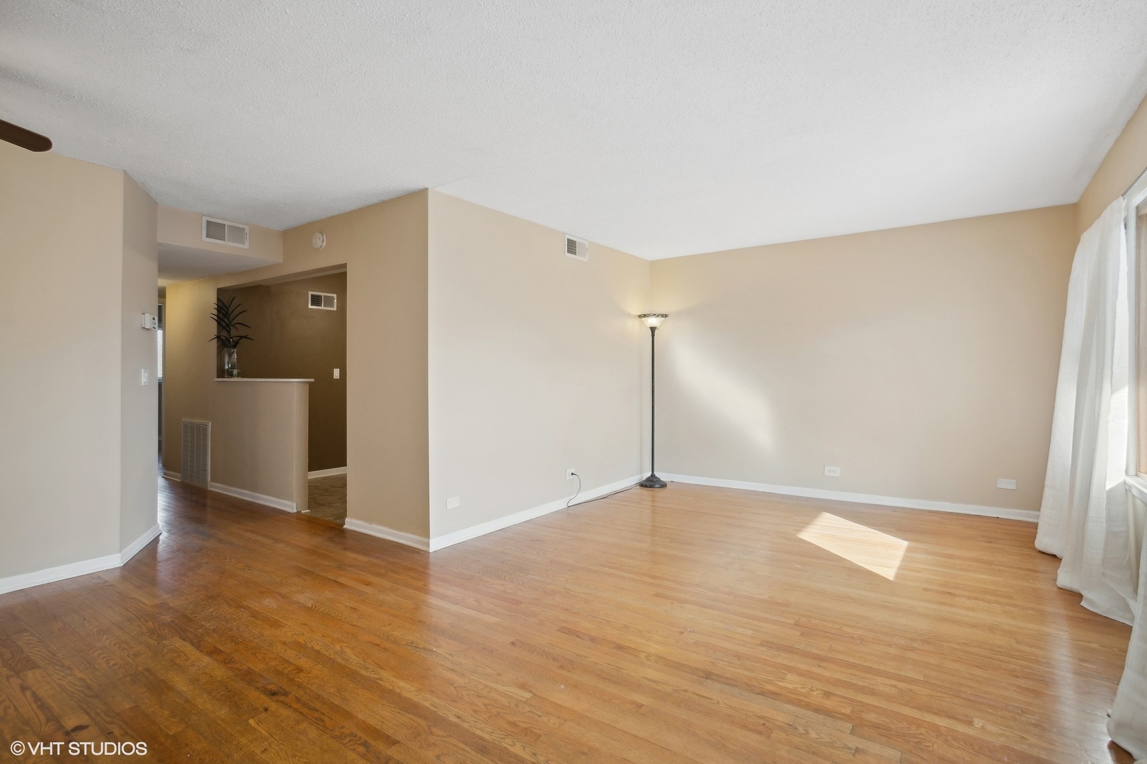9624 West Higgins Road, Unit 3FN Rosemont, IL 60018 - Photo 2 of 12 a view of an empty room with wooden floor and a window