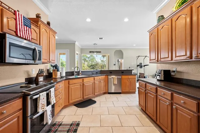 a kitchen with stainless steel appliances granite countertop a stove a sink and a microwave