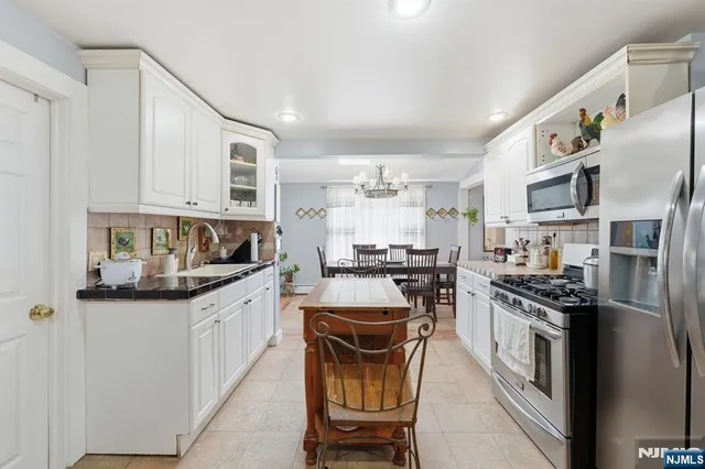 a kitchen with stainless steel appliances granite countertop a stove top oven a sink dishwasher and cabinets with wooden floor