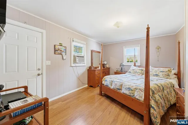 a bedroom with a bed and wooden floor
