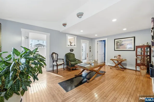 a living room with furniture hard wood floor and a potted plant
