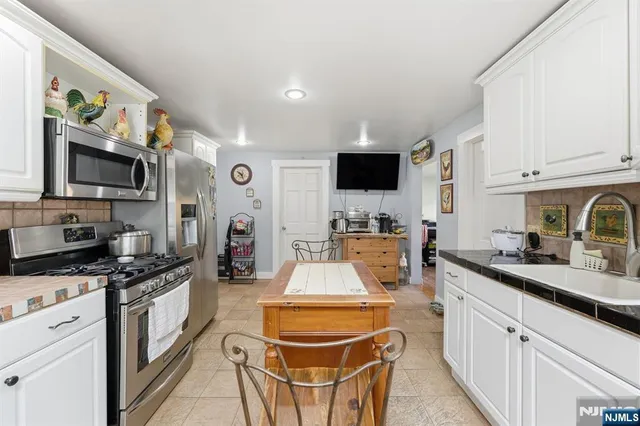a kitchen with granite countertop a sink stove and cabinets