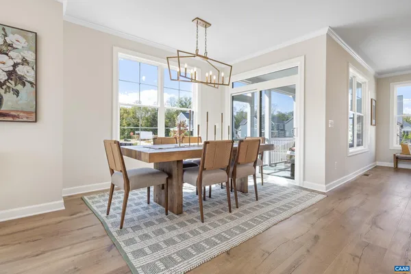a kitchen with stainless steel appliances a dining table chairs refrigerator and sink