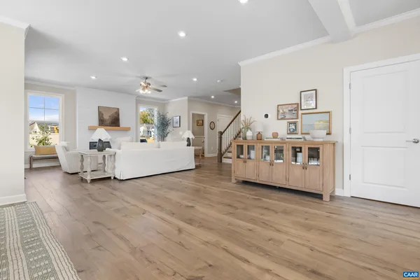 a kitchen with stainless steel appliances granite countertop a dining table chairs refrigerator and microwave