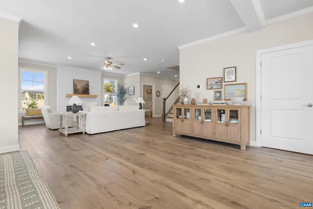 a kitchen with stainless steel appliances granite countertop a dining table chairs refrigerator and microwave