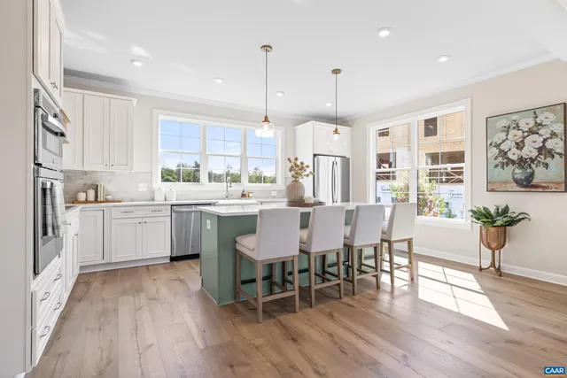 a large kitchen with kitchen island a large island a sink appliances and a living room view