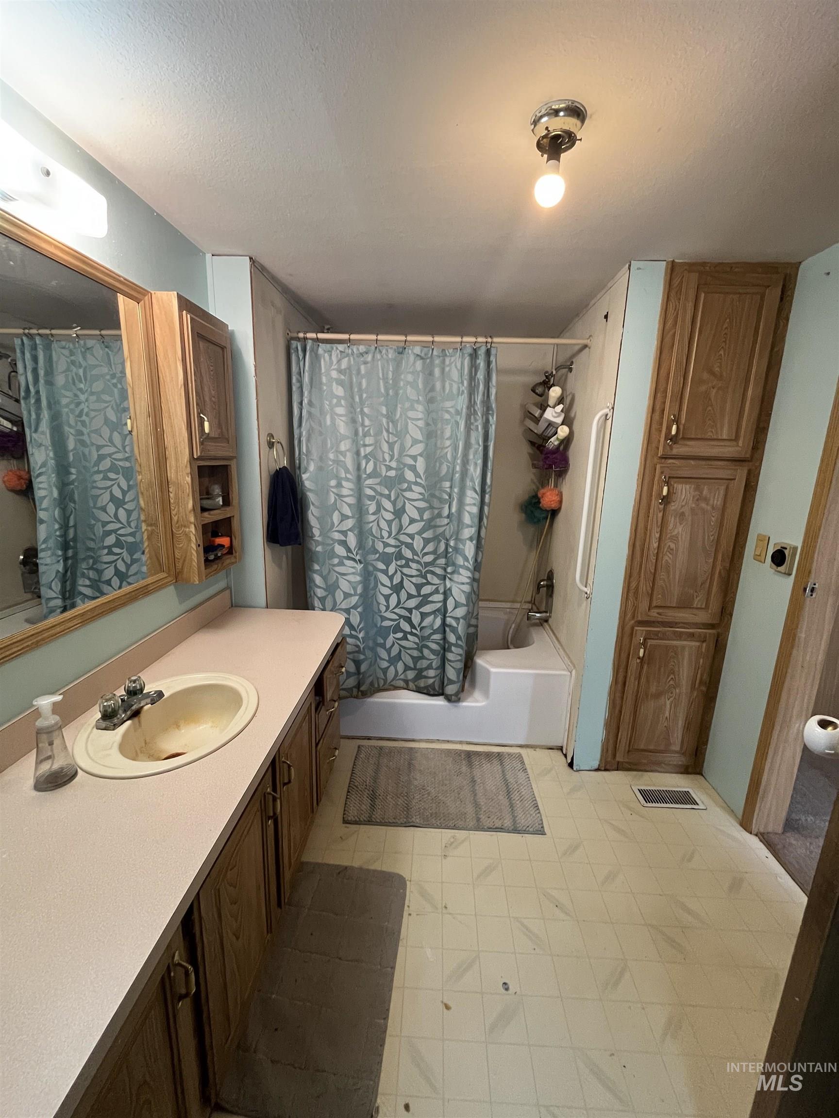 3175 Tomer Road, Unit 36 Moscow, ID 83843 - Photo 11 of 16 Vanity with an integrated sink, wood-finish cabinetry, and overhead lighting