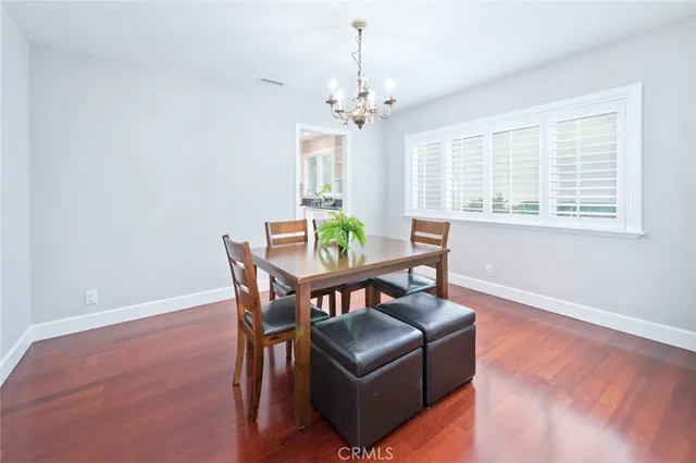 a kitchen with stainless steel appliances a refrigerator a stove a sink and white cabinets with wooden floor