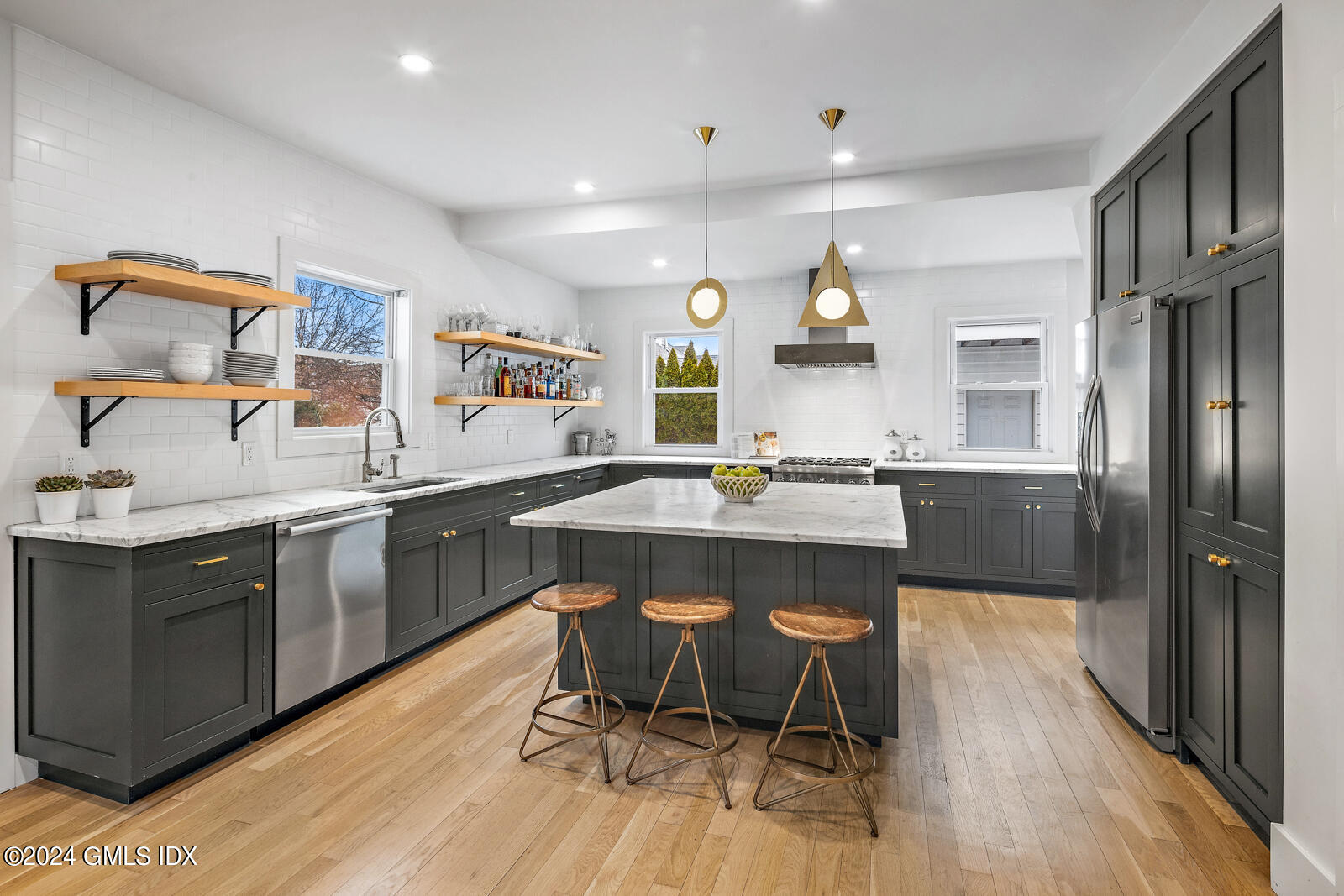 15 Elm Place Greenwich, CT 06830 - Photo 1 of 40 a kitchen with a table chairs refrigerator and wooden cabinets