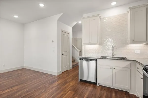 a kitchen with granite countertop a stove a sink and a microwave