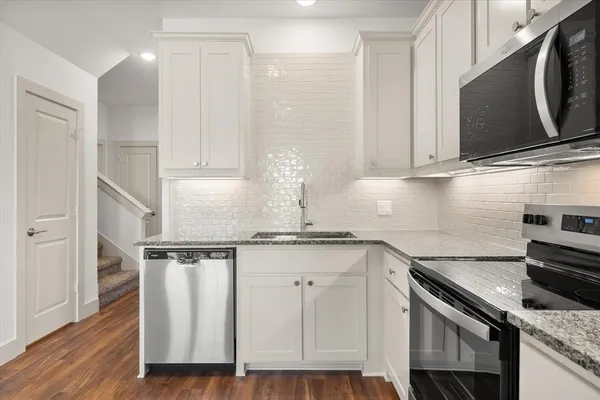 a kitchen with a refrigerator sink and cabinets