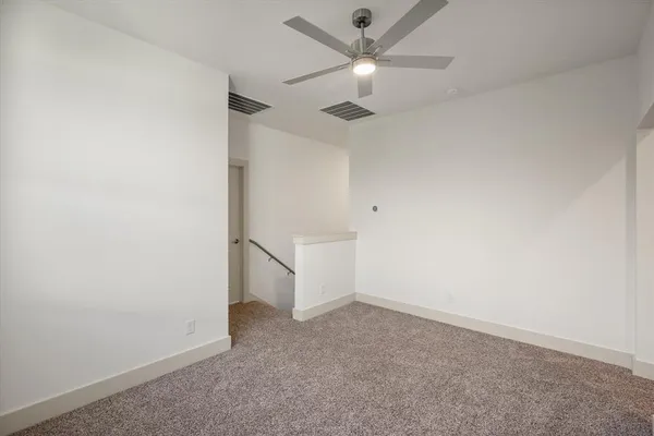 an empty room with a ceiling fan and a window