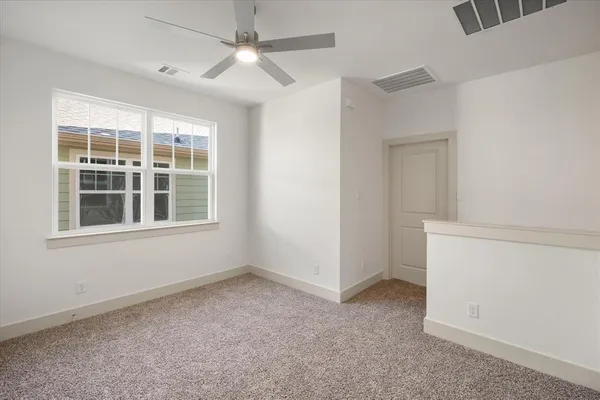 an empty room with a window and a fan