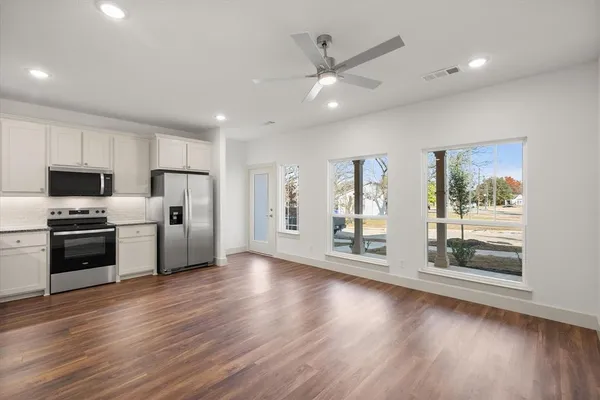 a kitchen with a refrigerator a sink and cabinets